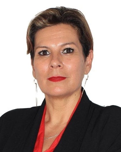 Porträt von Mariela Matthies in schwarzem Blazer und roter Bluse, mit verschränkten Armen.